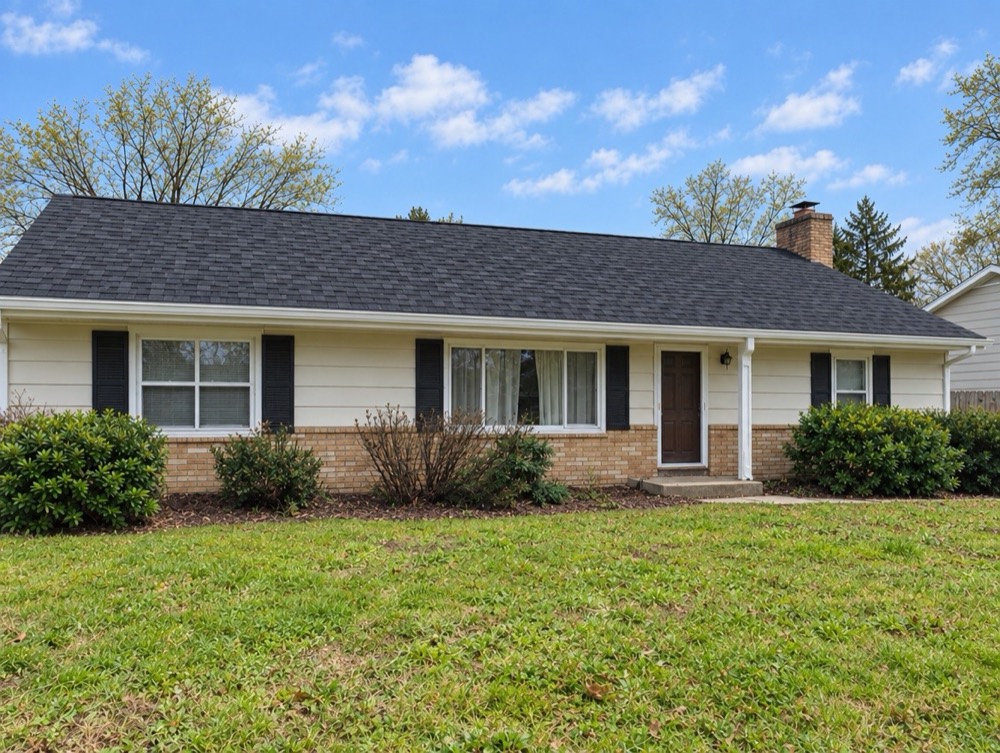 The same ranch home with a new charcoal shingle roof after replacement